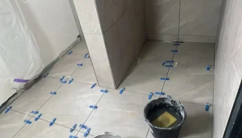 Handwerker beim sorgfältigen Verlegen von Fliesen
